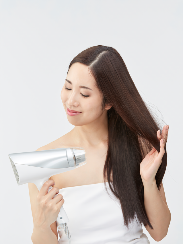 ドライヤーで髪を乾かす女性