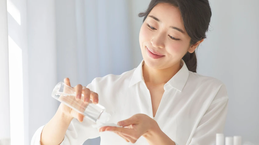 化粧水をコットンに含ませてスキンケアを行う女性